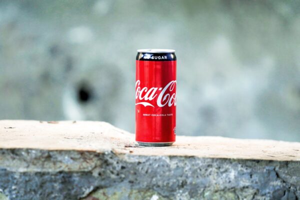 coca cola can on brown concrete surface